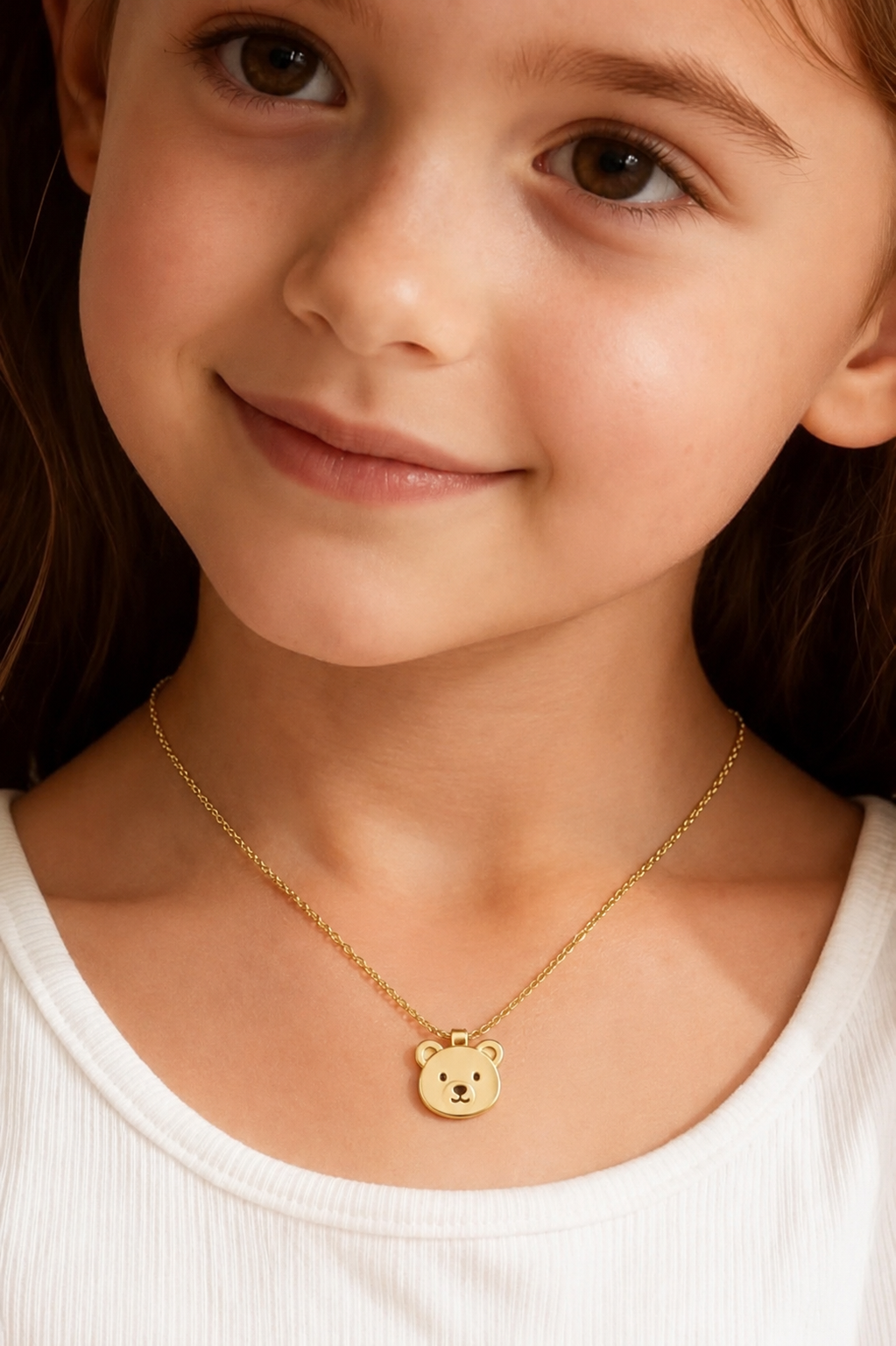Smiling child wearing the gold-toned teddy bear pendant necklace