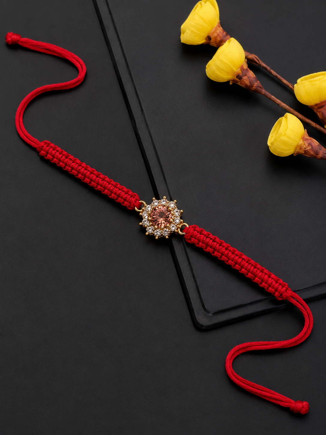 Gold pink floral rakhi on red thread