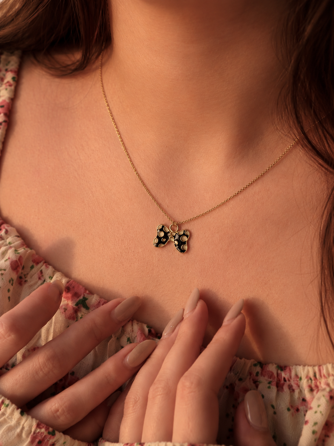 Close-up of the spotted butterfly pendant necklace worn at the neckline