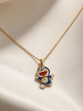 Gold-toned chain with blue and white enamel cartoon character pendant on a cream surface
