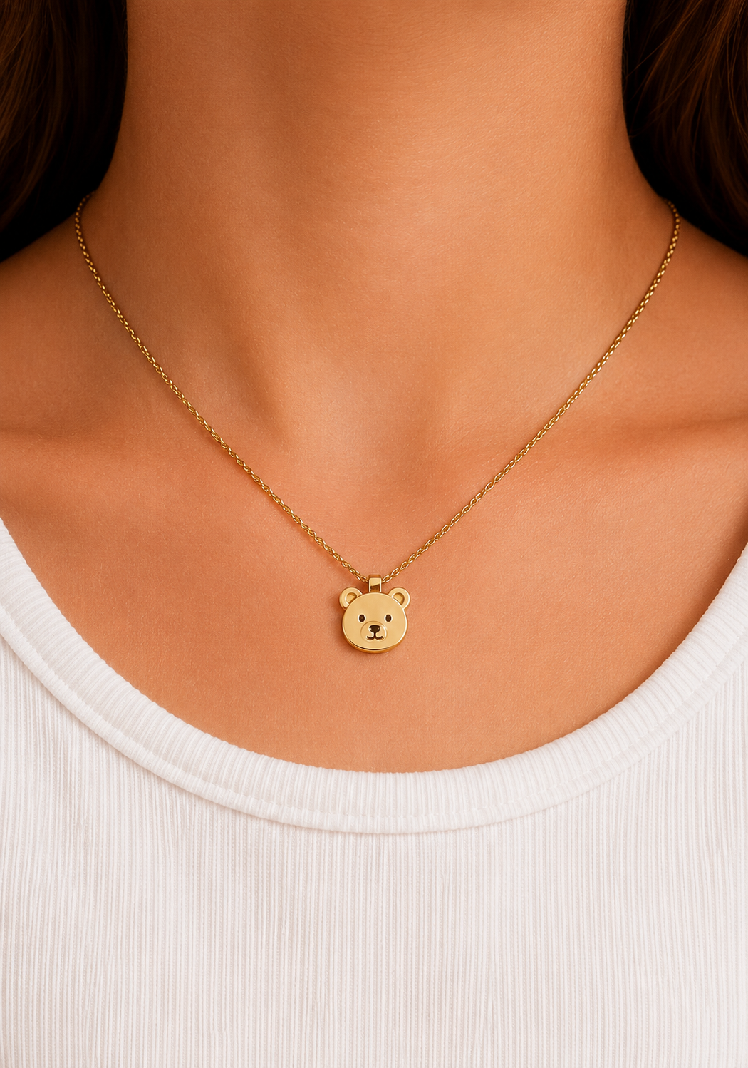 Model in a white top wearing the gold-toned teddy bear pendant necklace