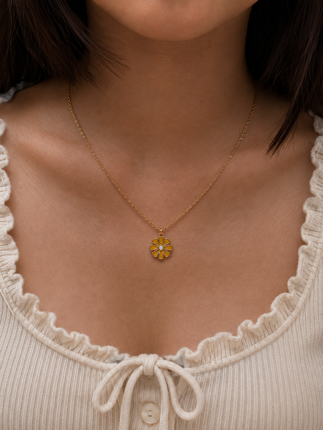 Model in a cream top wearing the mustard daisy enamel pendant necklace