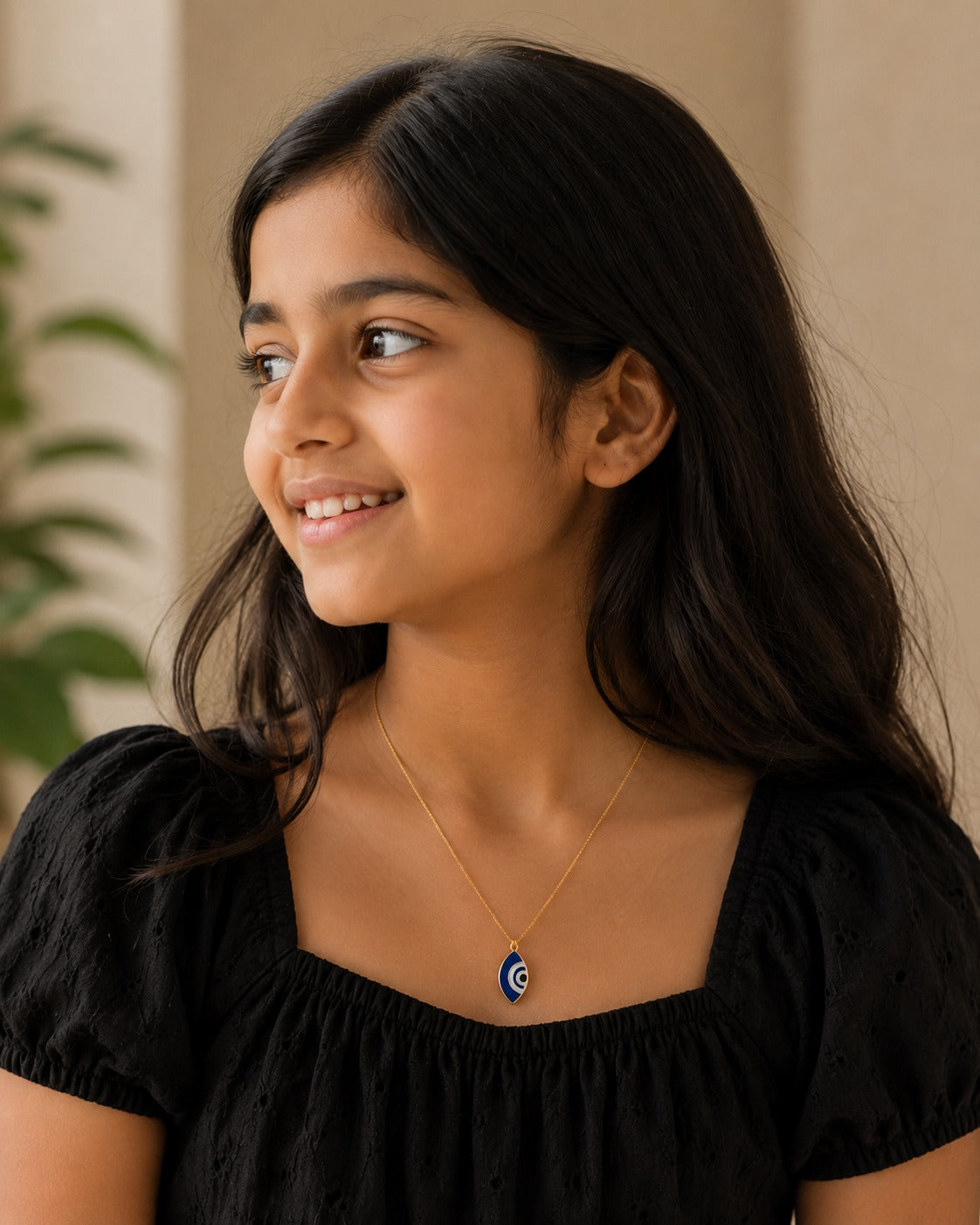 Model wearing the blue marquise evil eye pendant on a fine gold-toned chain