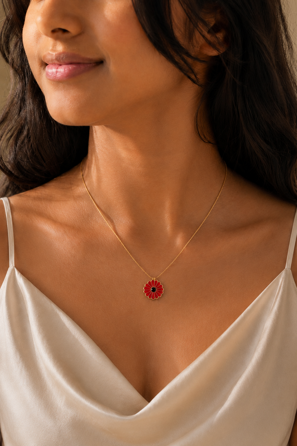 Woman wearing the red daisy enamel pendant necklace with an ivory slip top
