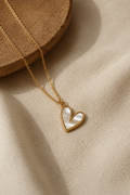 Gold-toned heart pendant necklace with white mother-of-pearl inlay on linen