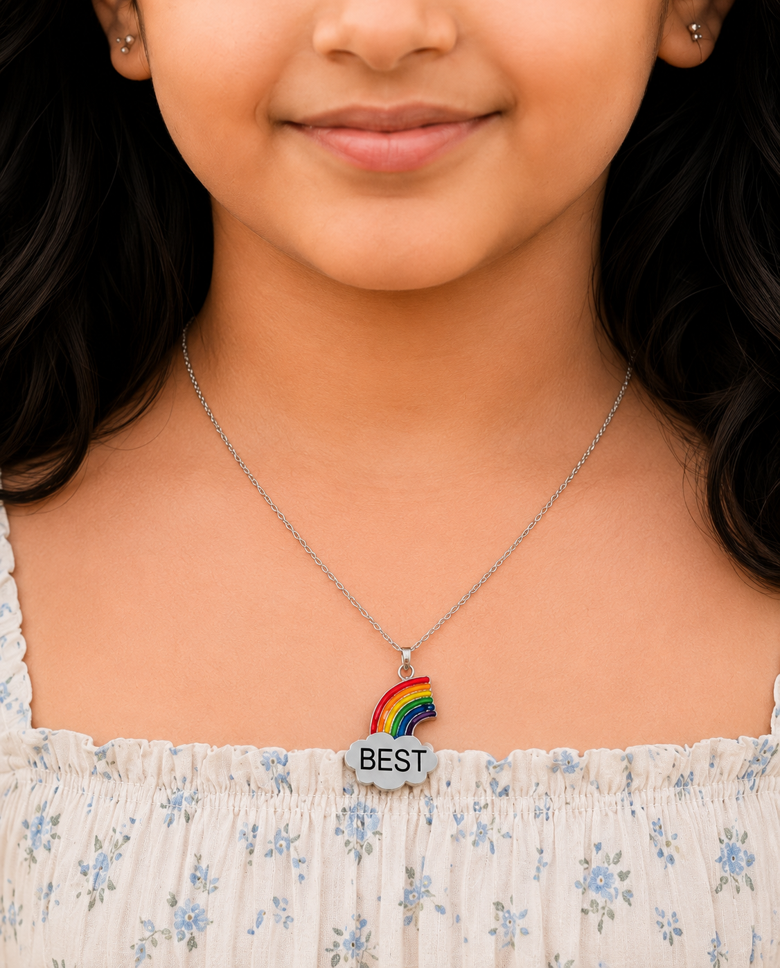 Girl wearing the rainbow cloud charm necklace with a floral top