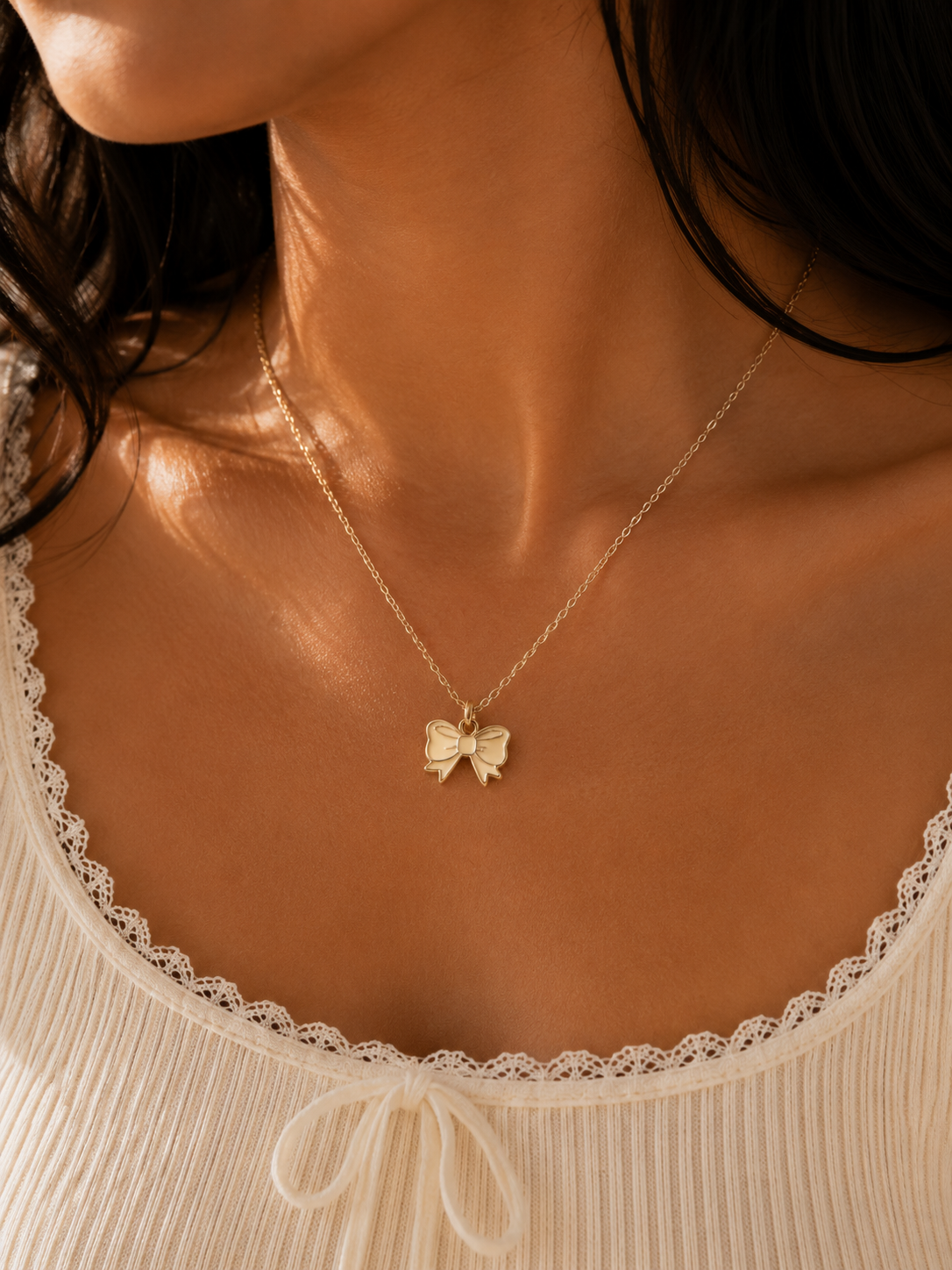 Gold-toned bow pendant detail