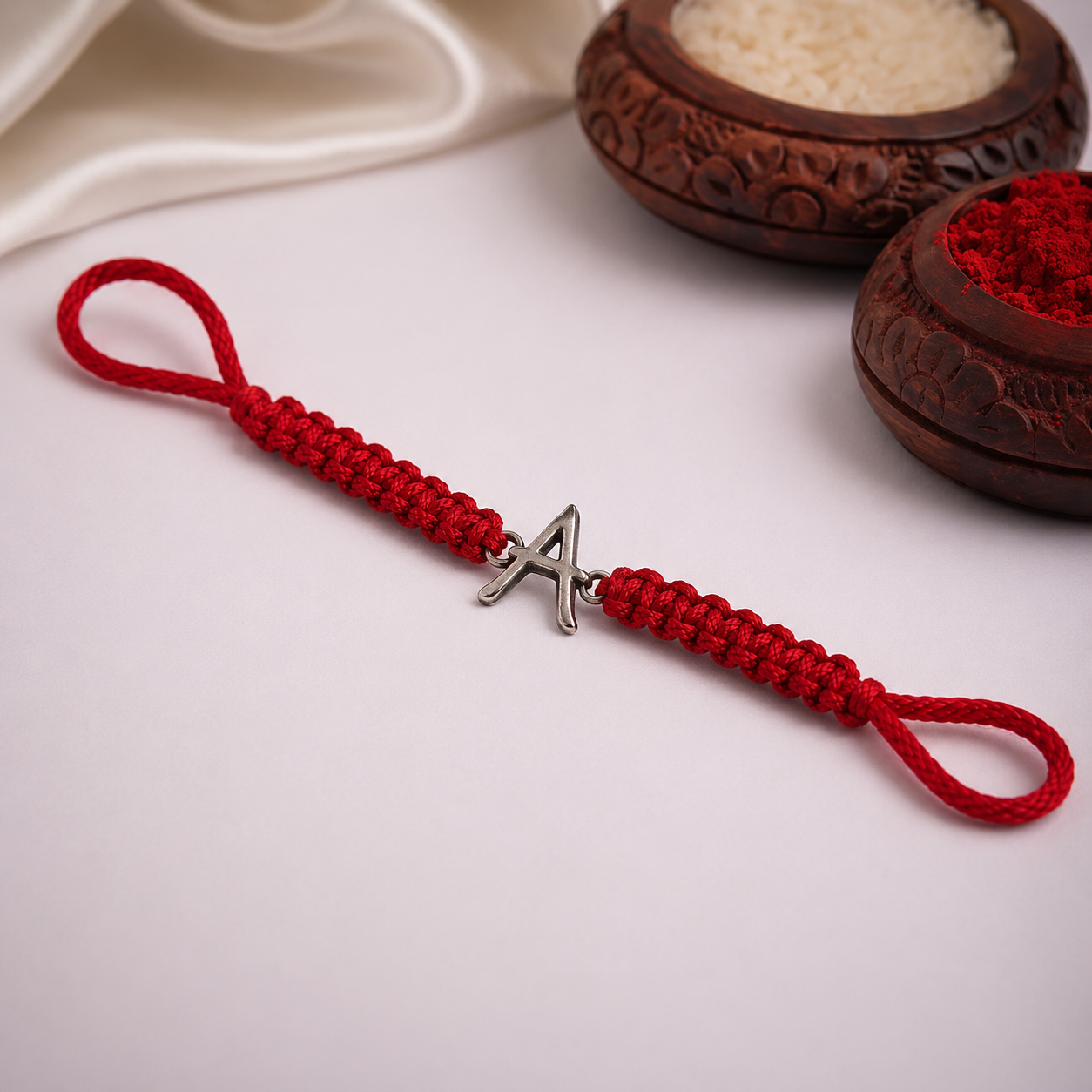 Silver initial A red thread rakhi